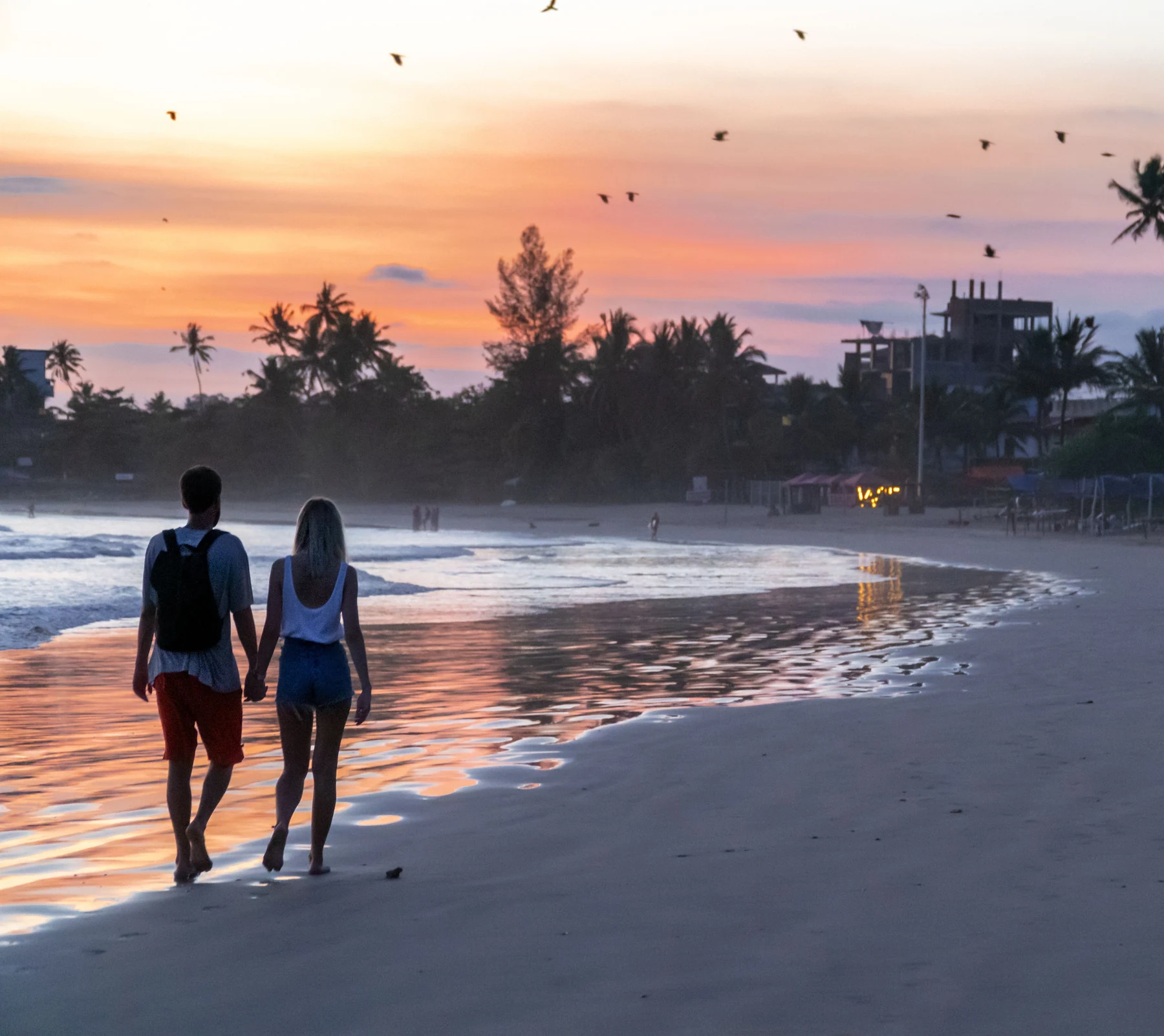 Couple walking together on a Sri Lankan beach at sunset